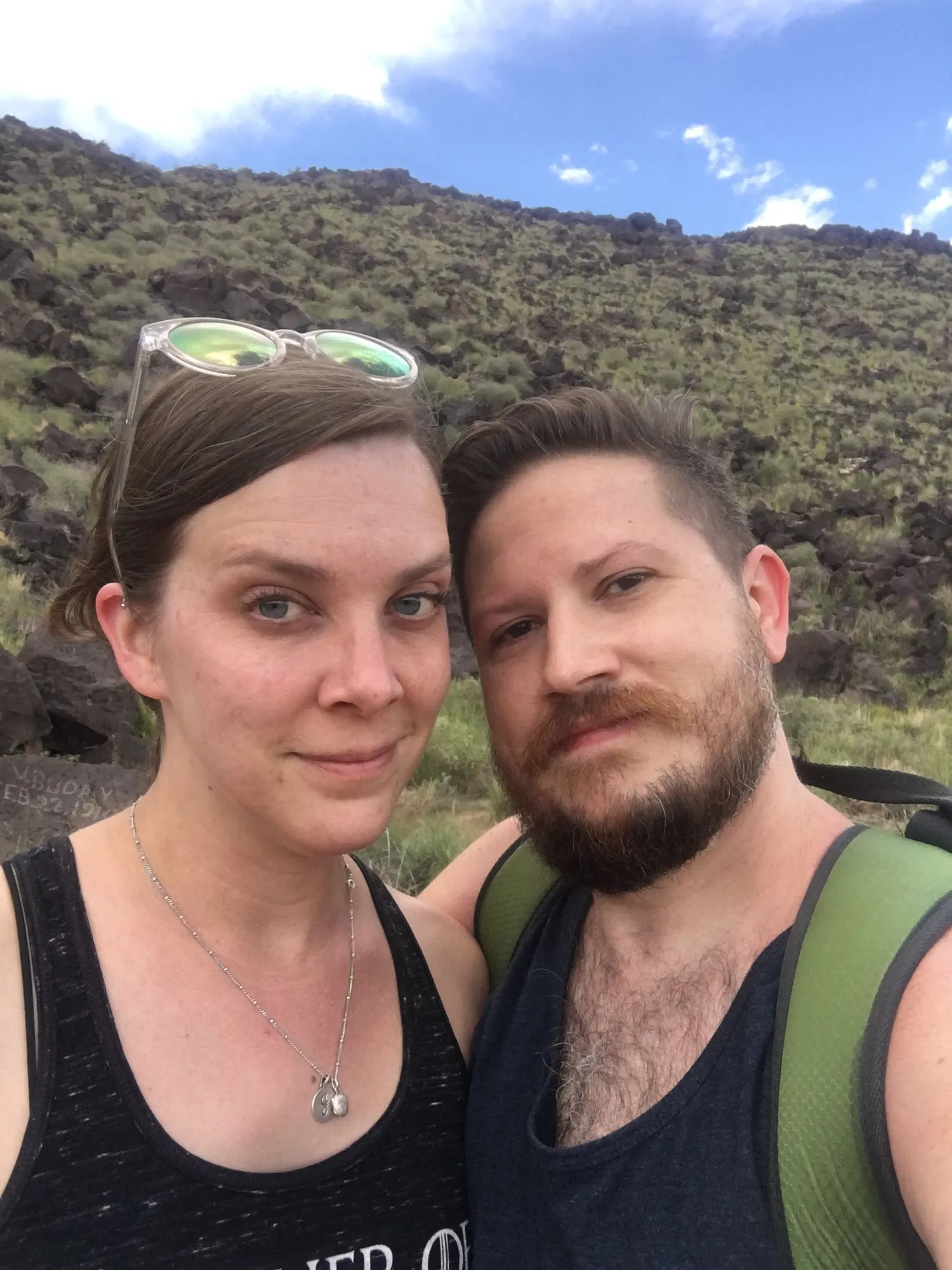 Us hiking below a hillside of dark lava rock